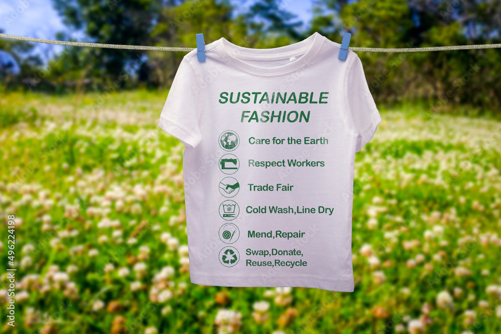A T-shirt with sustainable fashion tips hanging outdoors.