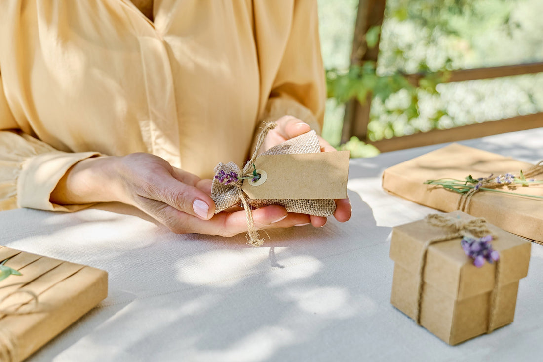 Woman arranging eco-friendly kraft paper gift boxes for corporate gifting in 2026